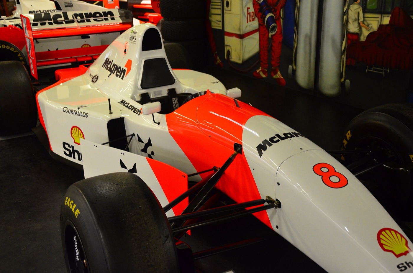 Red and white McLaren MP4/8 number 8 with Shell, Courtaulds and Boss logos on display, a second McLaren behind it