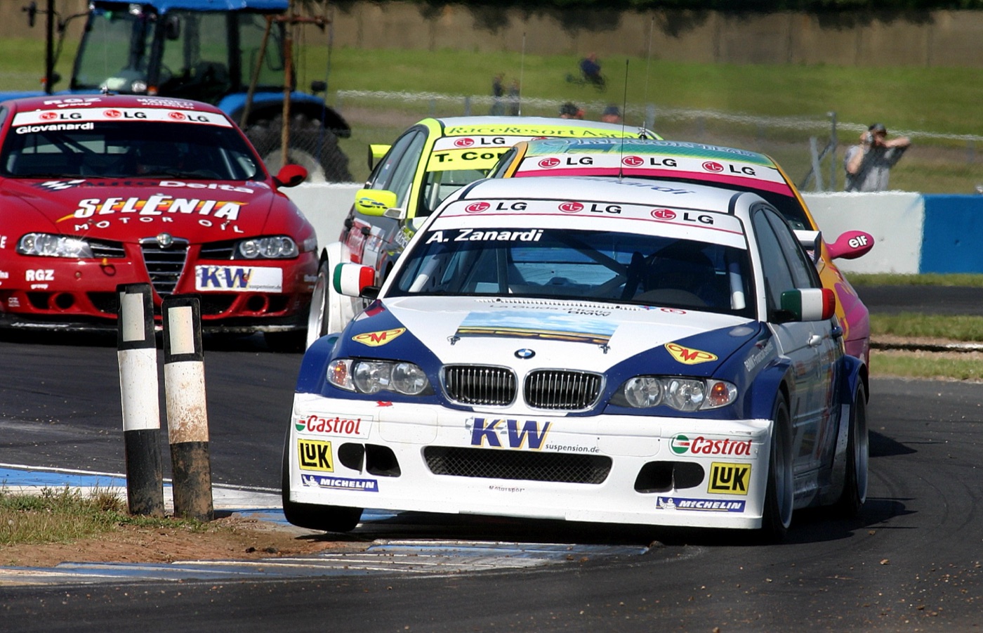 White and blue BMW 320i touring car with A. Zanardi on the windscreen leading other saloons at Donington Park