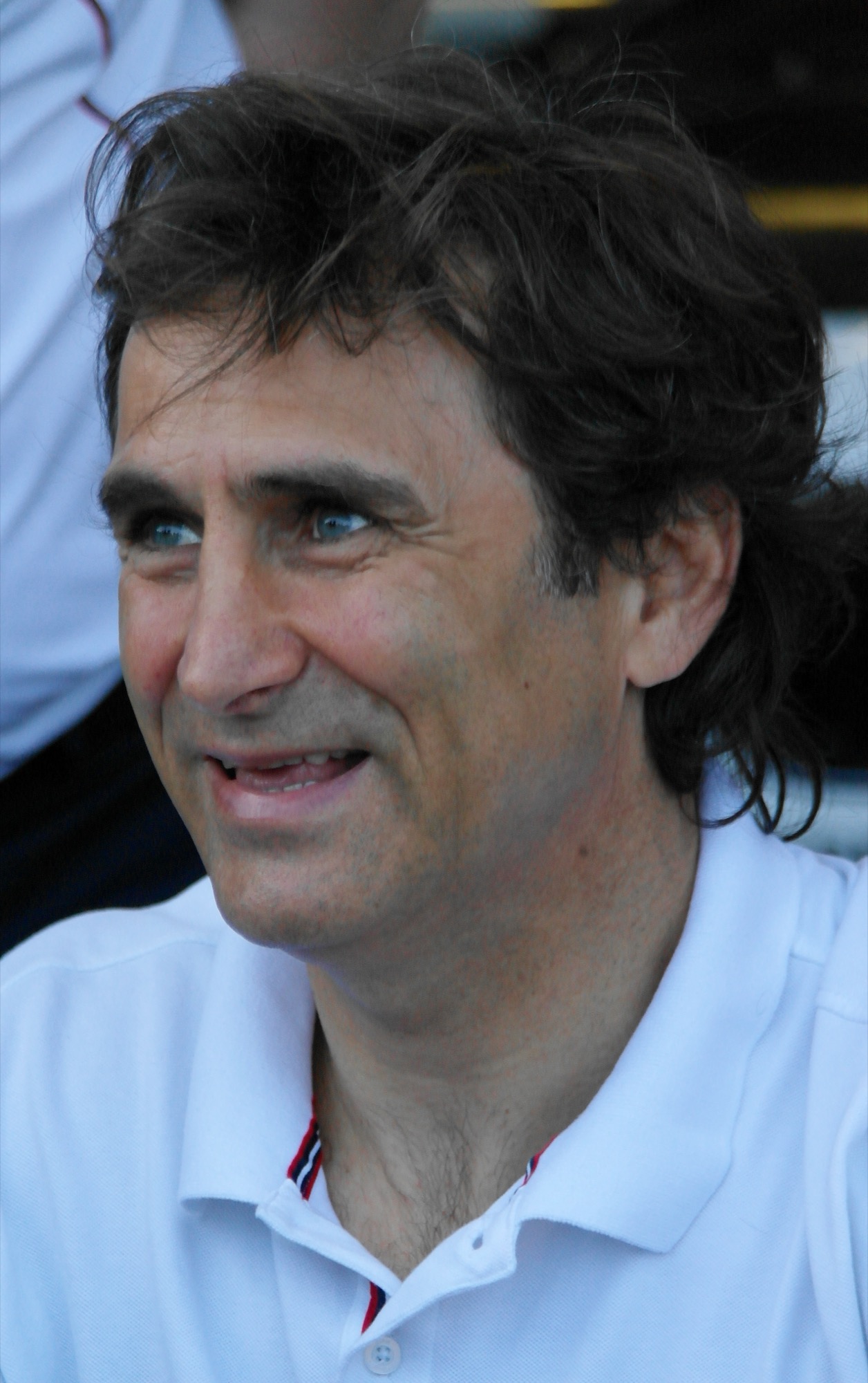 Head and shoulders portrait of Alex Zanardi smiling, in a white polo shirt
