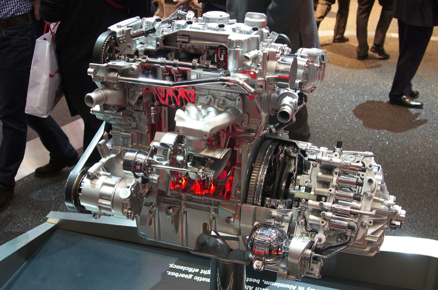Sectioned aluminium four-cylinder turbo engine joined to a twin-clutch gearbox on a show stand