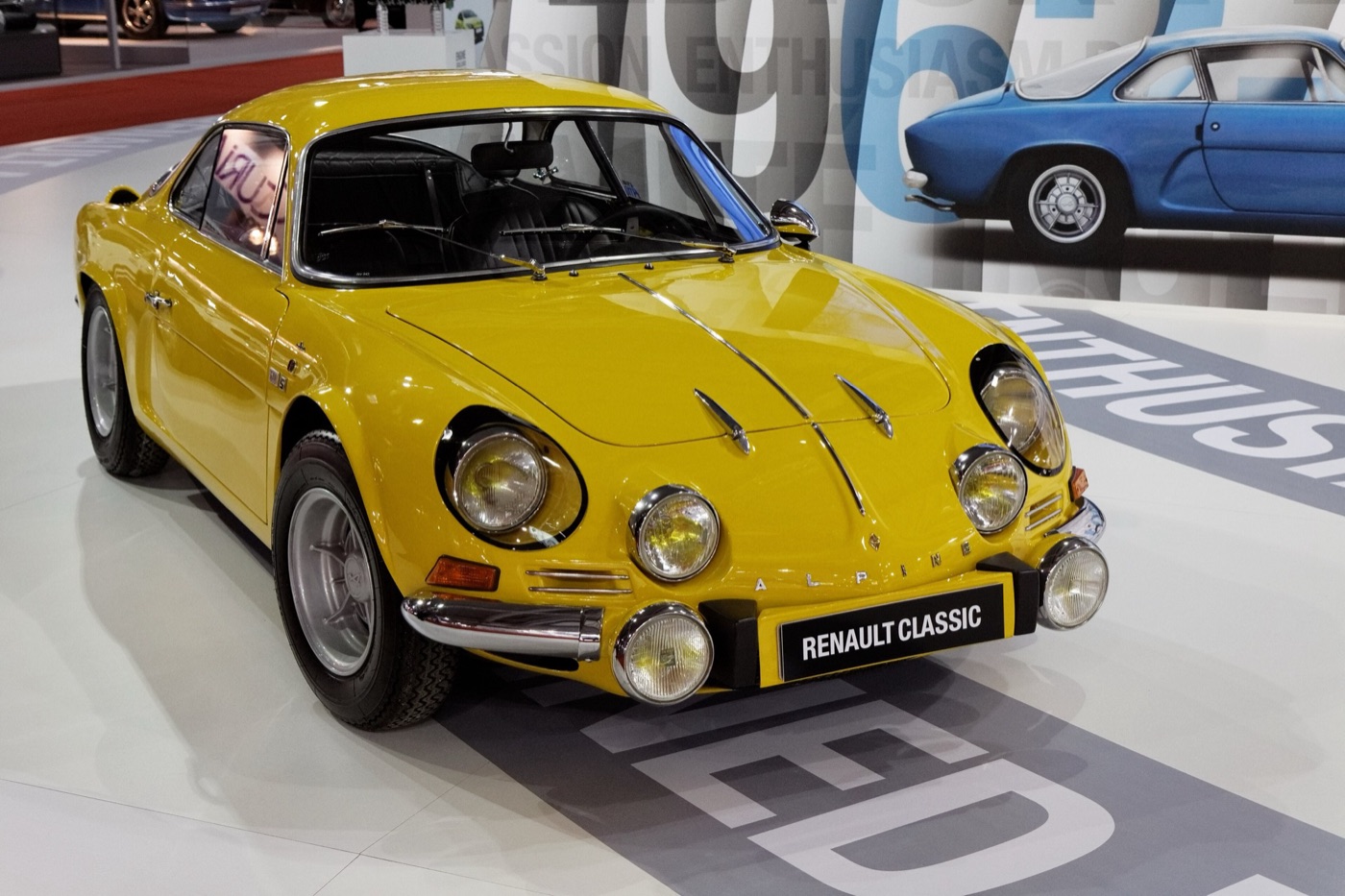 Yellow Alpine A110 1600S Berlinette with six front lamps on a Renault Classic show stand