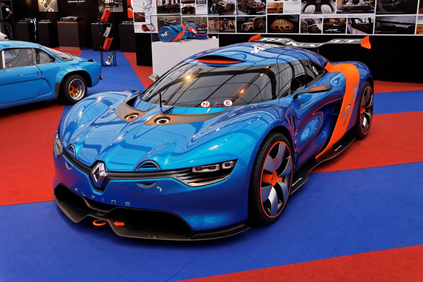 Blue and orange Renault Alpine A110-50 concept car with a large rear wing on a show stand