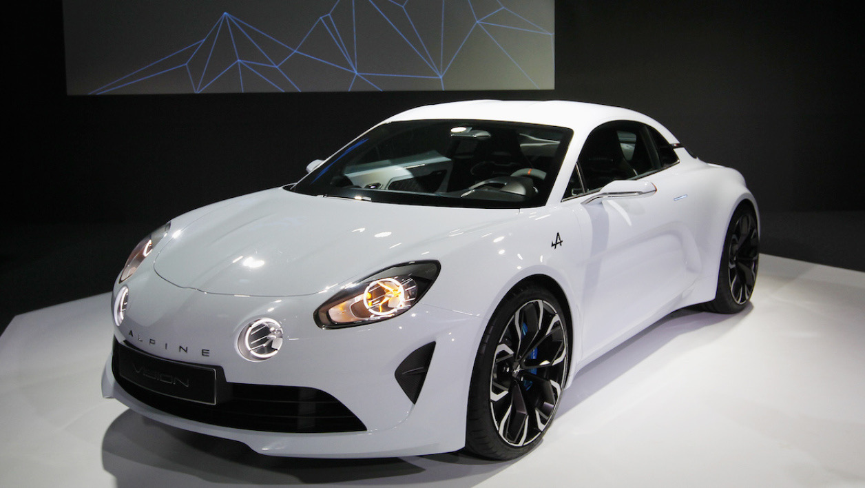 White Alpine Vision concept coupé with black wheels on a dark show stand