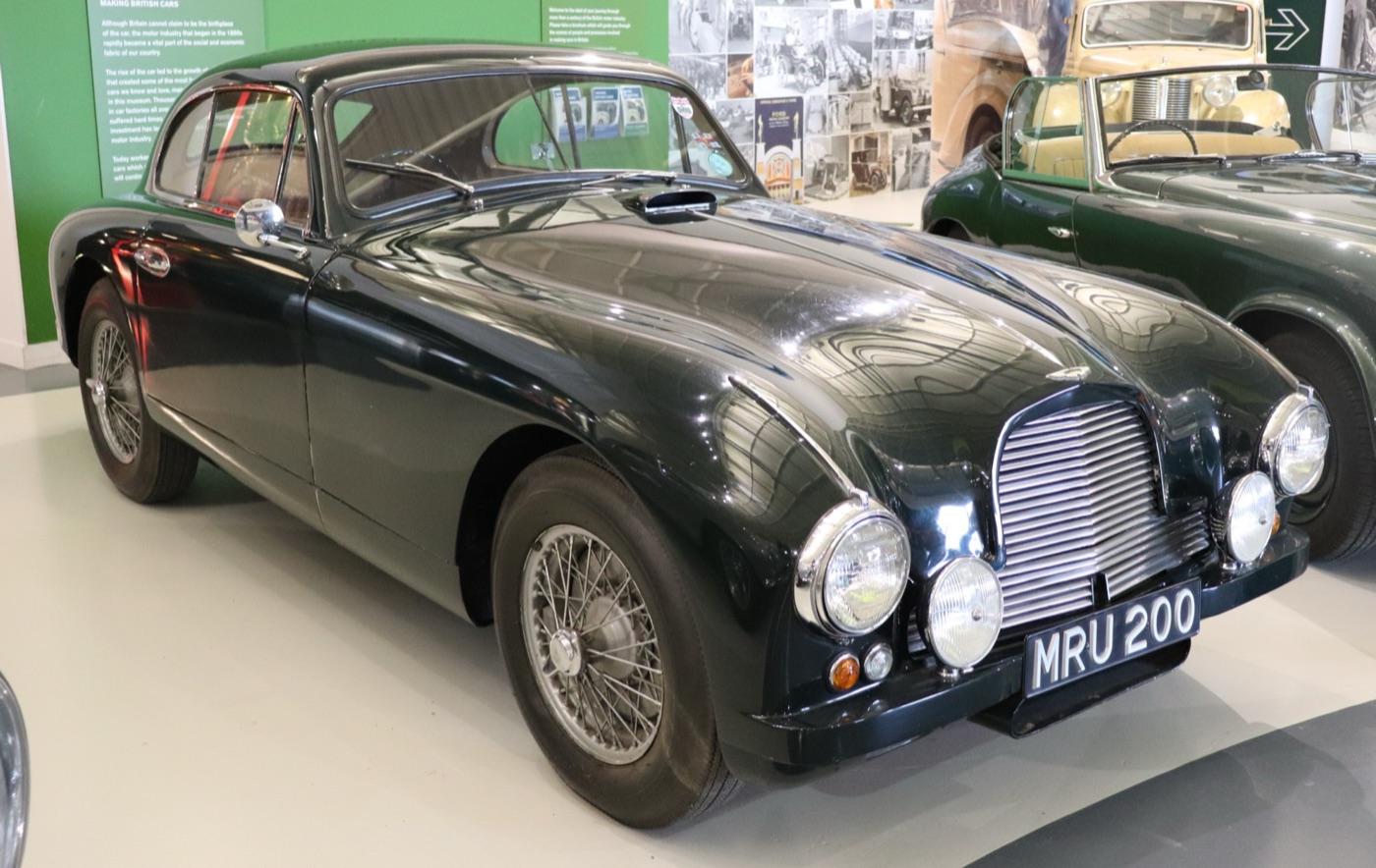Dark green 1952 Aston Martin DB2 coupé with wire wheels and registration MRU 200 in a museum hall