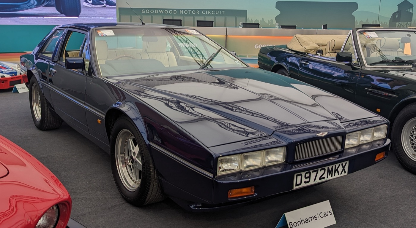 Dark blue 1986 Aston Martin Virage prototype mule with Lagonda-style quad headlamps, displayed indoors