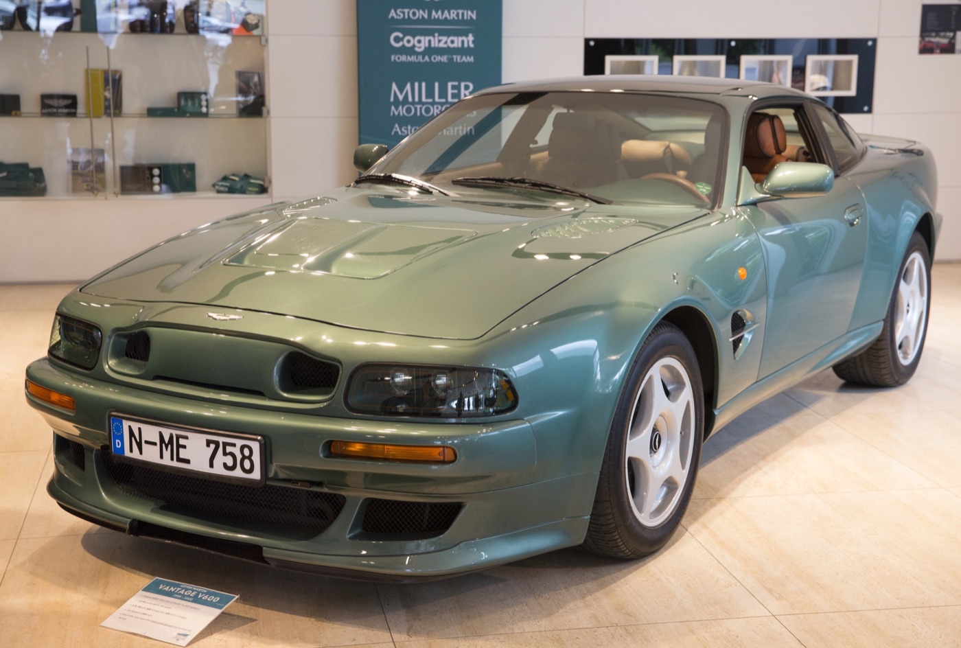 Almond Green 1999 Aston Martin Vantage Le Mans V600 with a two-opening nostril grille and DBR1-style wing vents in a showroom