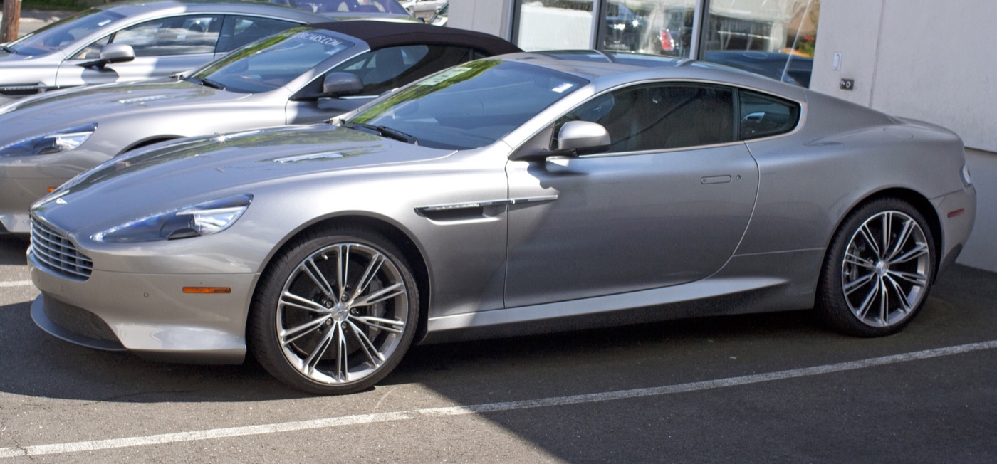 Silver 2012 Aston Martin Virage coupe in side view with a five-bar grille, LED side strake and 20-inch wheels
