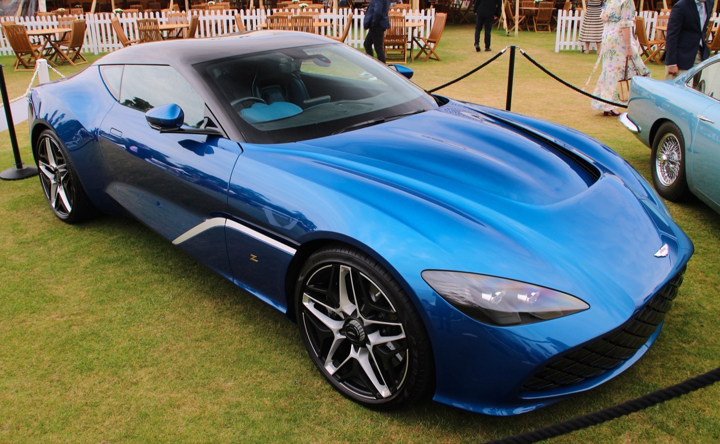 Blue Aston Martin DBS GT Zagato with a frameless lattice grille and a bonnet vent, parked on grass at an outdoor show