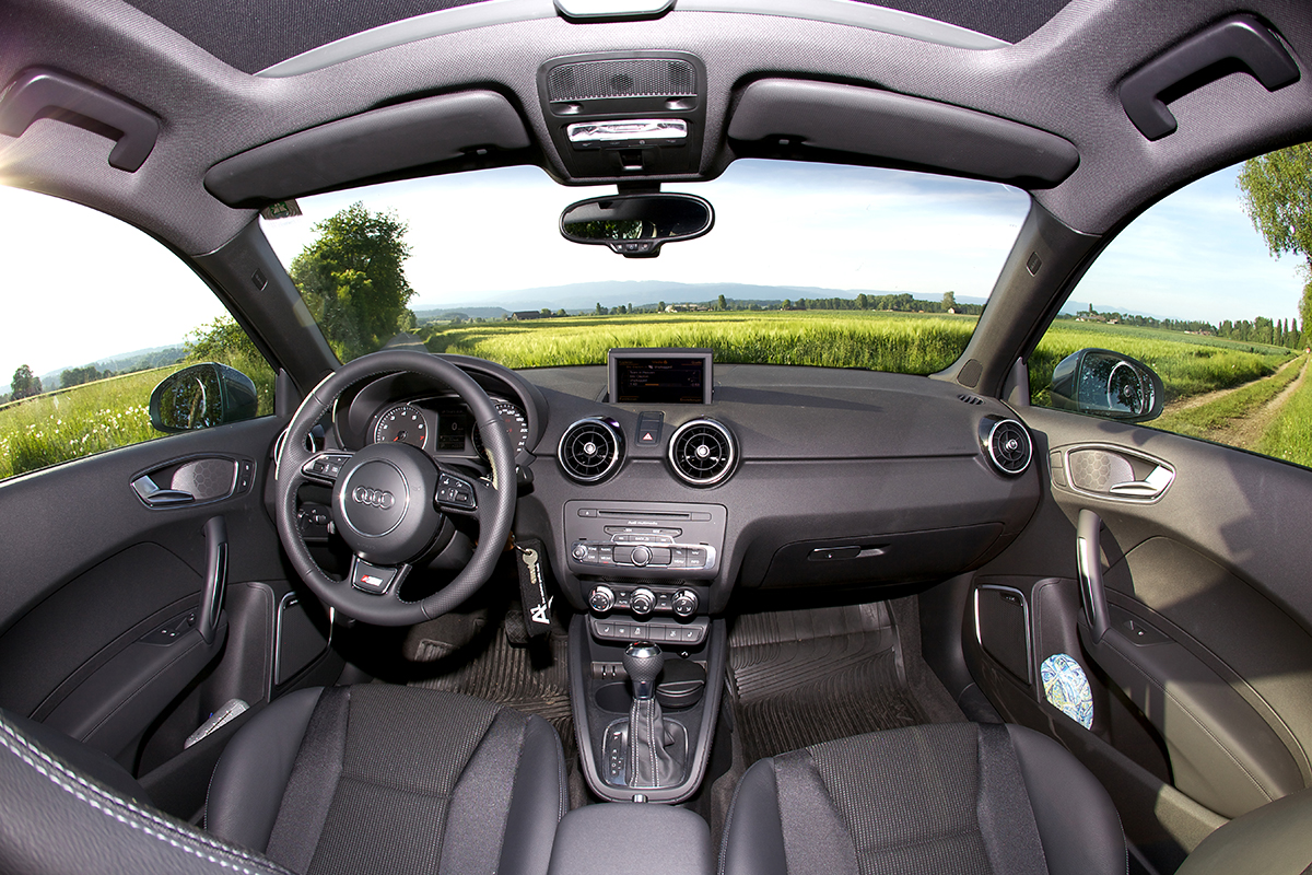 Wide-angle view of an Audi A1 Mk1 dashboard with round air vents and a pop-up screen