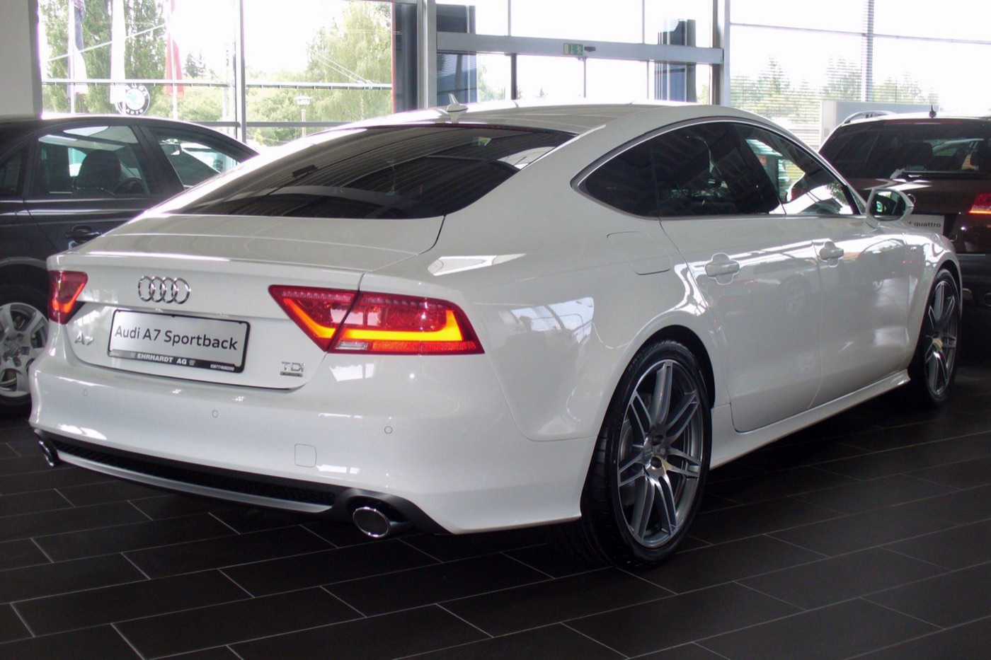 White Audi A7 Sportback 3.0 TDI quattro S line from the rear three-quarter, showing the sloping fastback tailgate