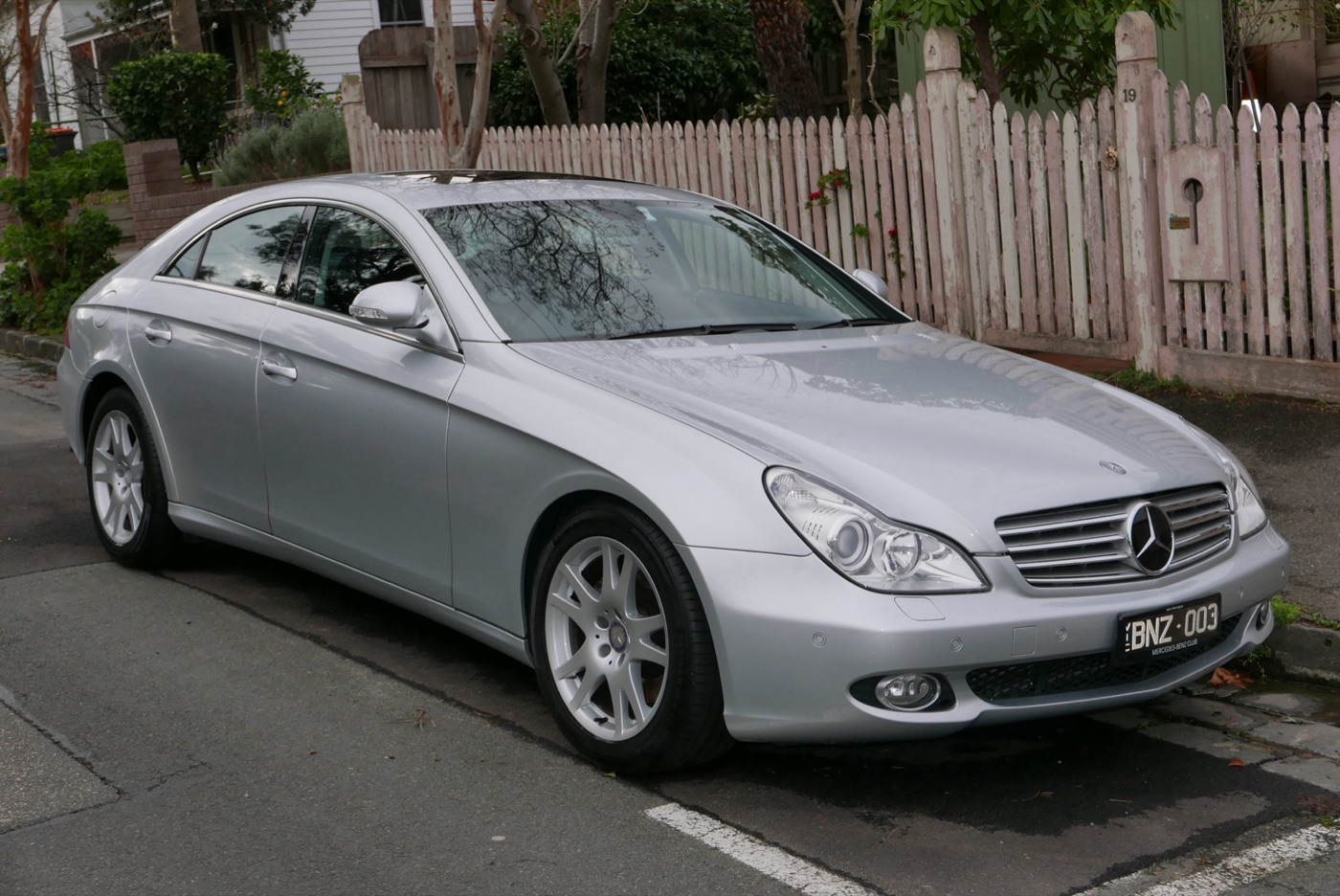 Silver first-generation Mercedes-Benz CLS 350 four-door coupé parked at a kerb