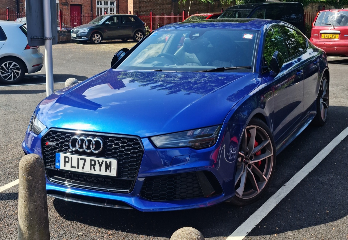 Blue facelifted Audi RS 7 Sportback performance with red brake calipers in a car park
