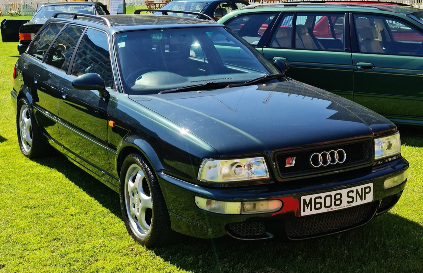 Dark green Audi RS2 with a British number plate and five-spoke Cup wheels on a lawn at a concours