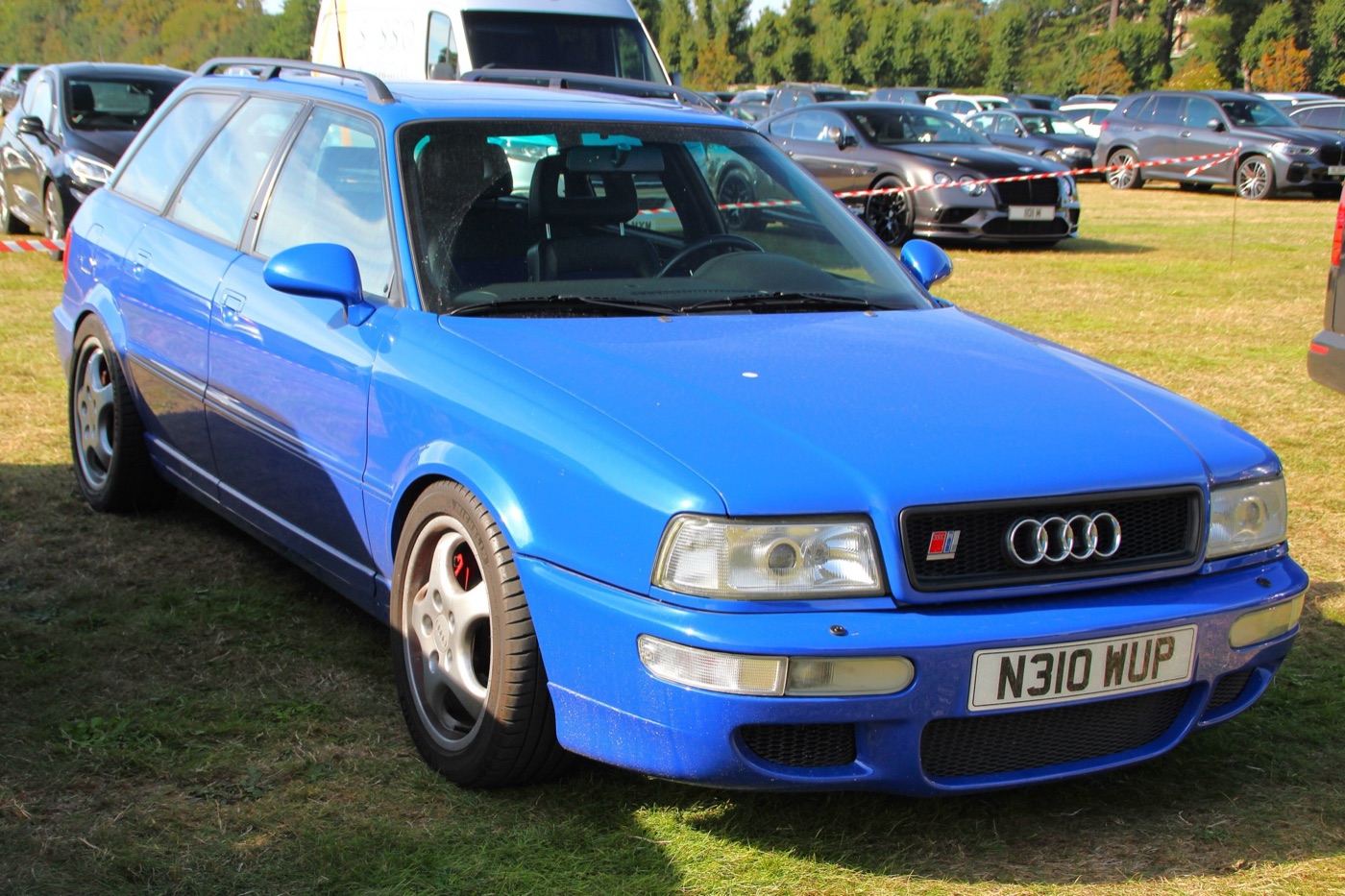 Nogaro blue Audi RS2 Avant with Porsche Cup wheels, red brake calipers and a British number plate, parked on grass