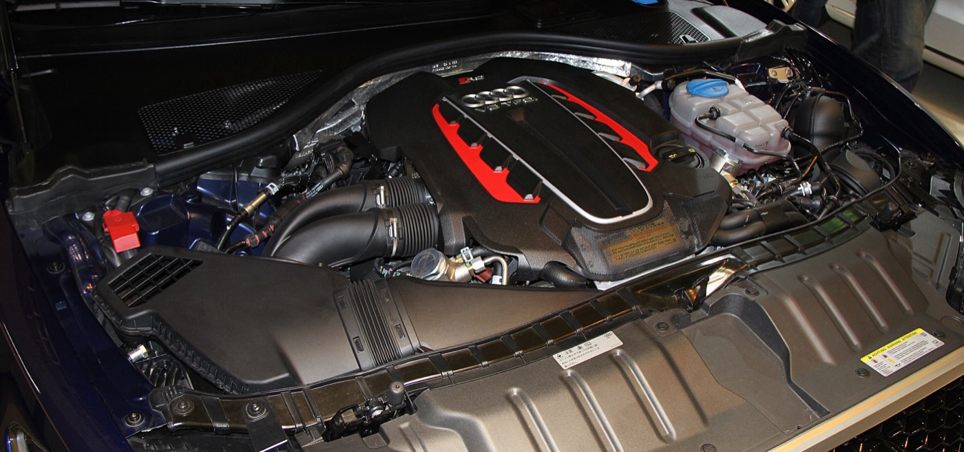 Engine bay of an Audi RS6 C7 showing the 4.0 TFSI V8 under a red and black engine cover