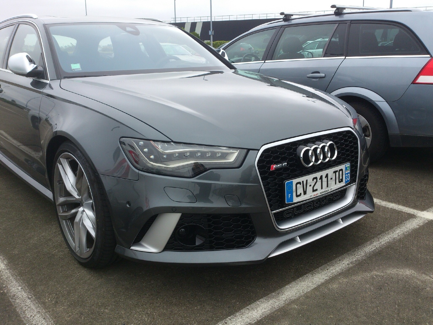 Grey Audi RS6 C7 Avant with a gloss black honeycomb grille, parked on French plates in 2013