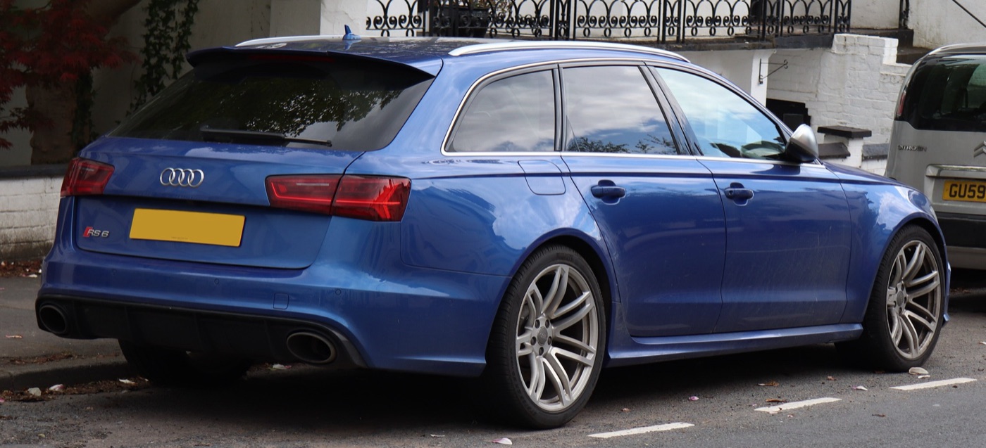 Blue Audi RS6 C7 Avant from the rear, showing its roof spoiler, diffuser and two oval tailpipes, parked in a street