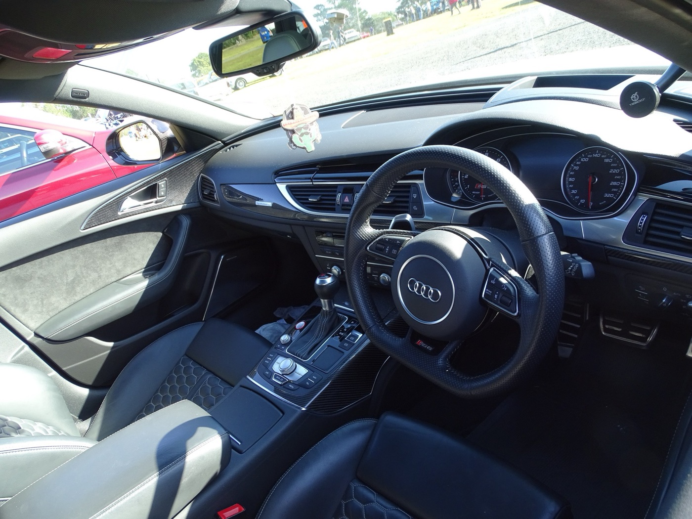 Right-hand-drive Audi RS6 C7 cockpit with a flat-bottomed steering wheel, carbon trim and black leather sports seats