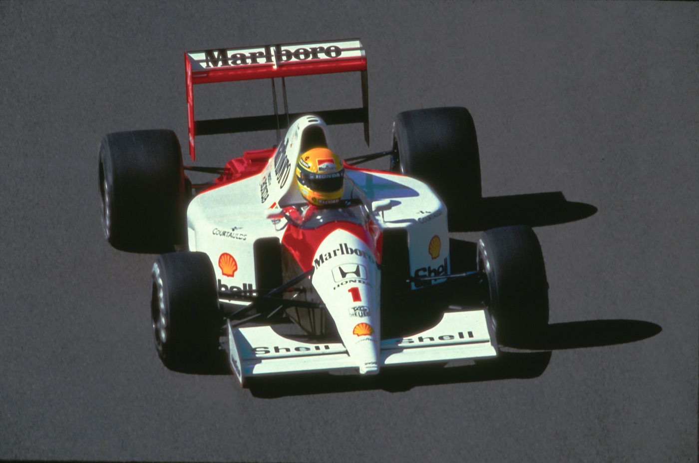 Ayrton Senna’s red and white McLaren-Honda, number 1, on track at Spa-Francorchamps in 1991, his yellow helmet visible