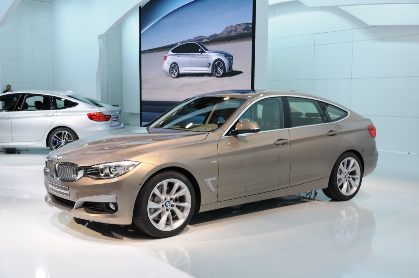 Bronze BMW 3 Series Gran Turismo hatchback on a white motor show stand