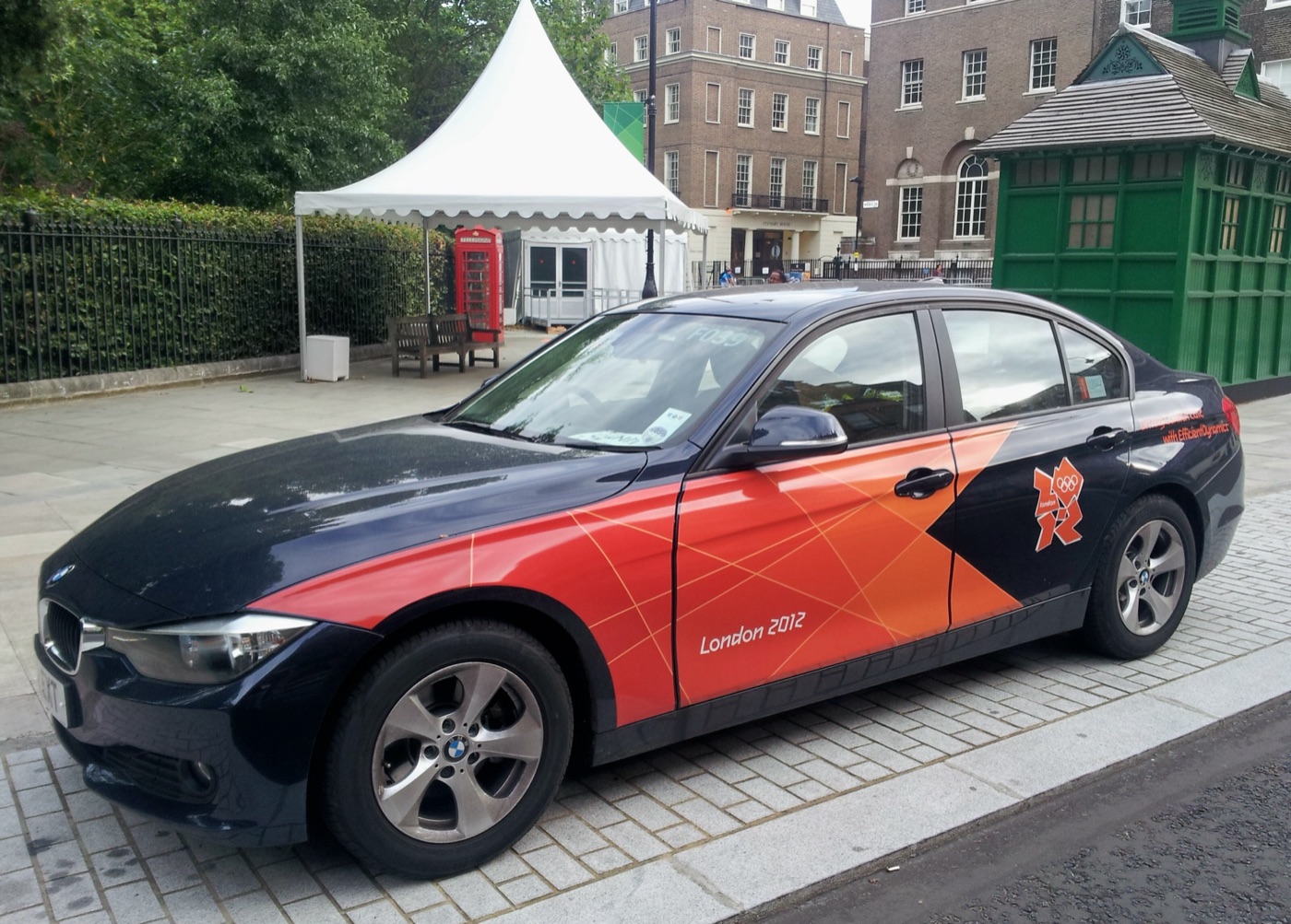 Dark blue BMW 3 Series saloon in orange London 2012 Olympic Games livery parked on a London street