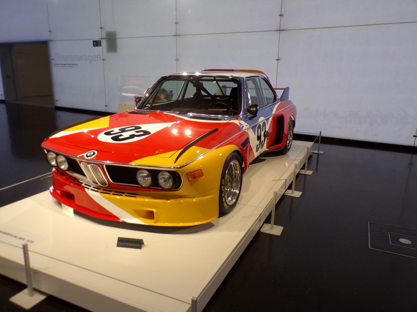 Alexander Calder’s BMW 3.0 CSL Art Car in red, yellow, blue and white with the race number 93, on a plinth at the BMW Museum