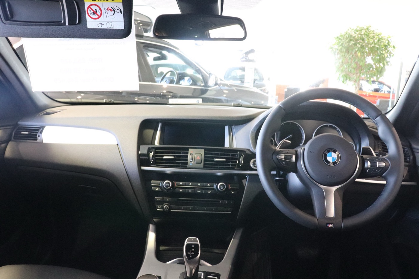 Dashboard of a right-hand-drive facelifted BMW X3 xDrive35d M Sport with iDrive screen, M steering wheel and gear selector