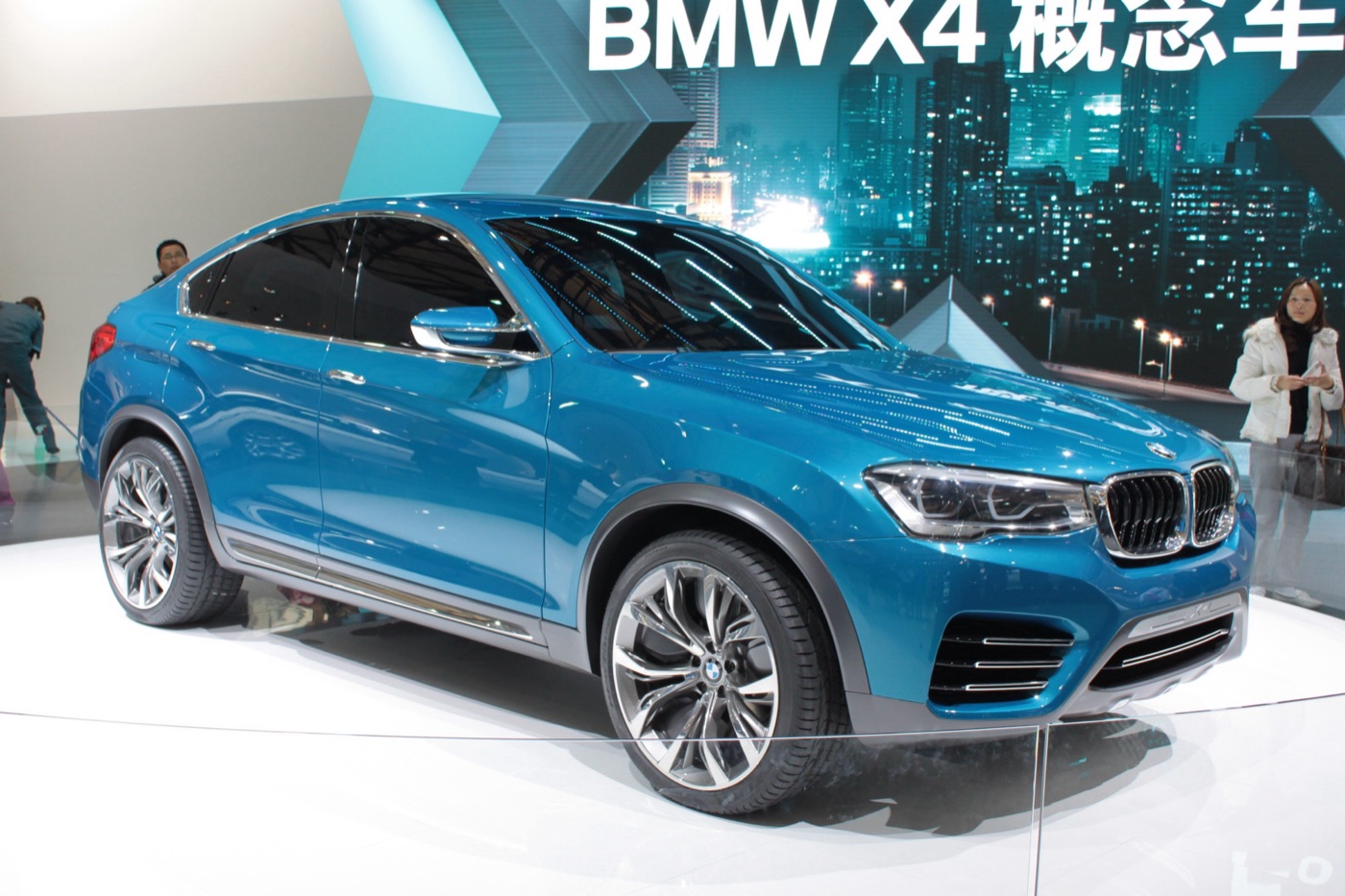 Light blue BMW X4 concept car on a white turntable under a sign reading BMW X4 in Chinese