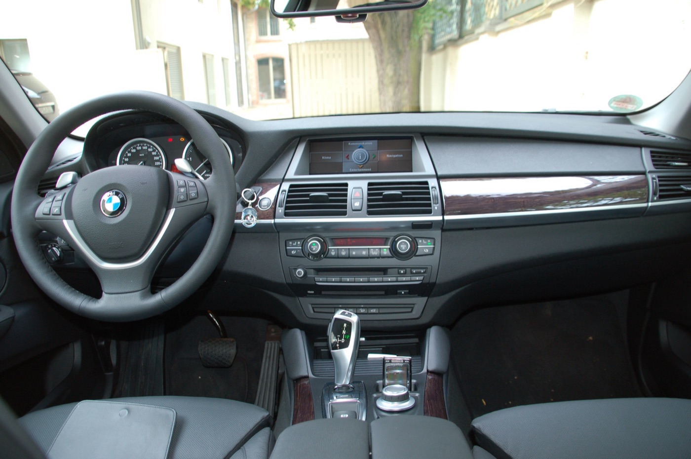 Dashboard of a BMW X6 xDrive35d with the iDrive screen, electronic gear selector and steering-wheel gearshift paddles