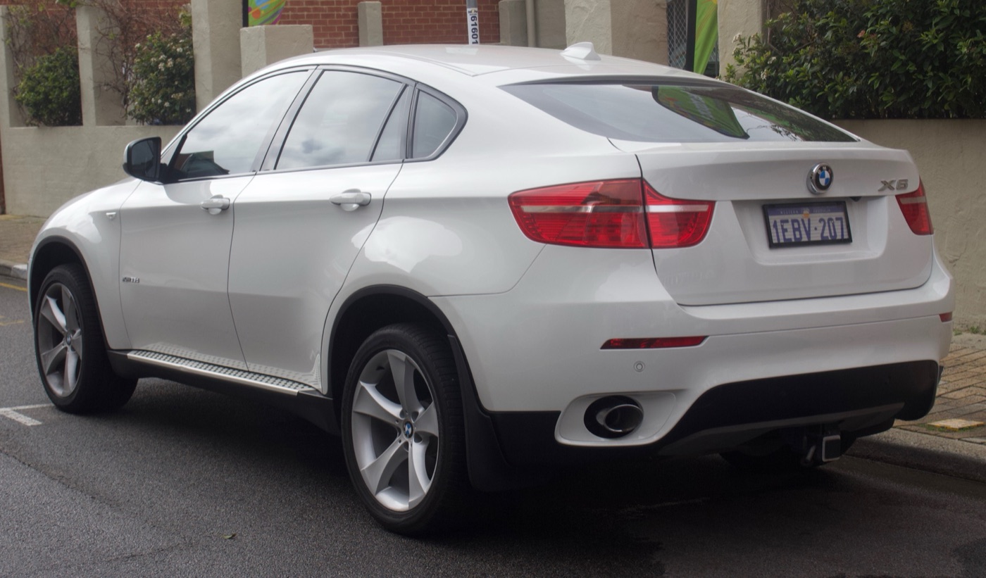 White BMW X6 E71 seen from the rear three-quarter, showing the sloping roofline running into the tailgate
