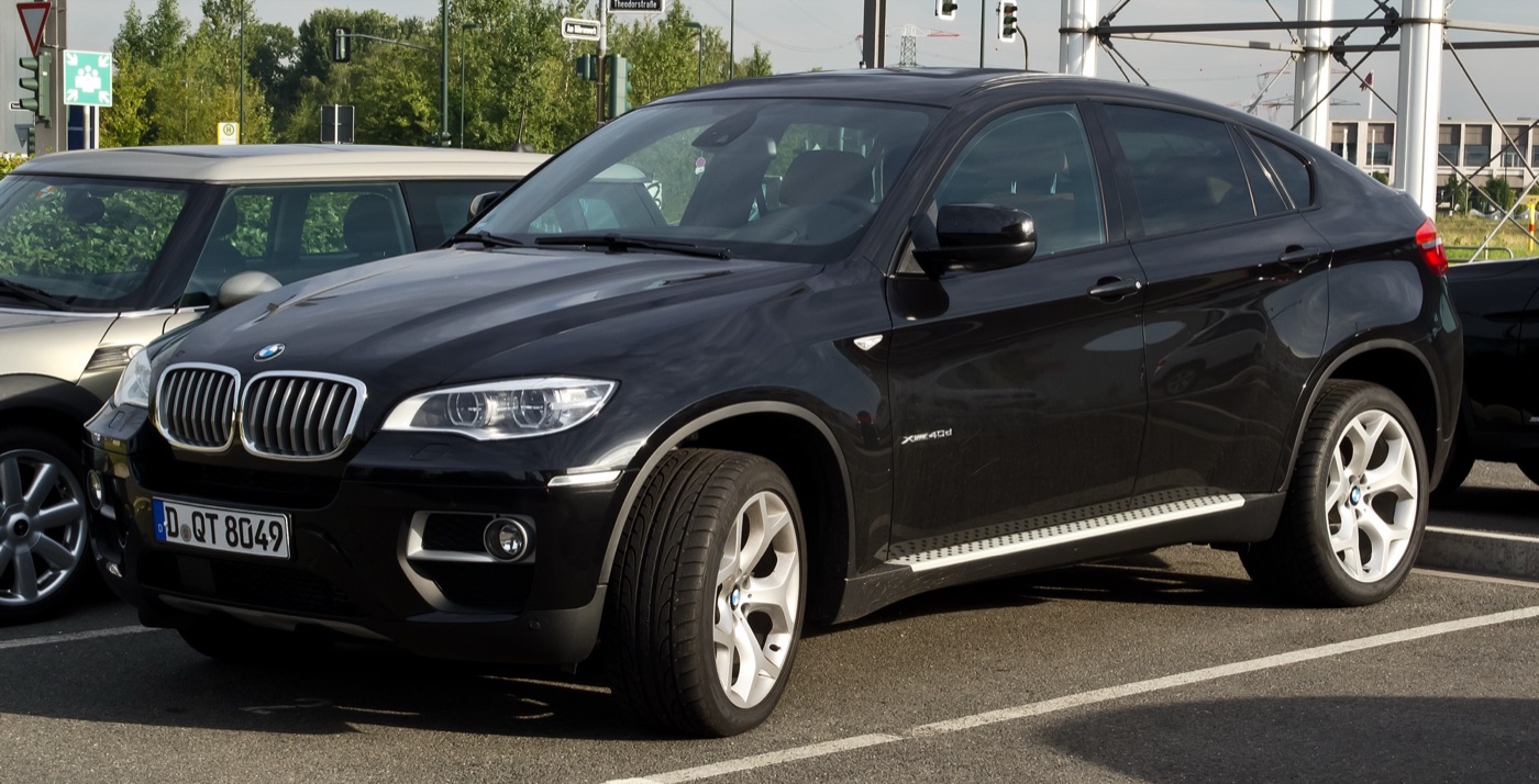 Black facelifted BMW X6 xDrive40d with LED-ringed headlights, parked in a car park