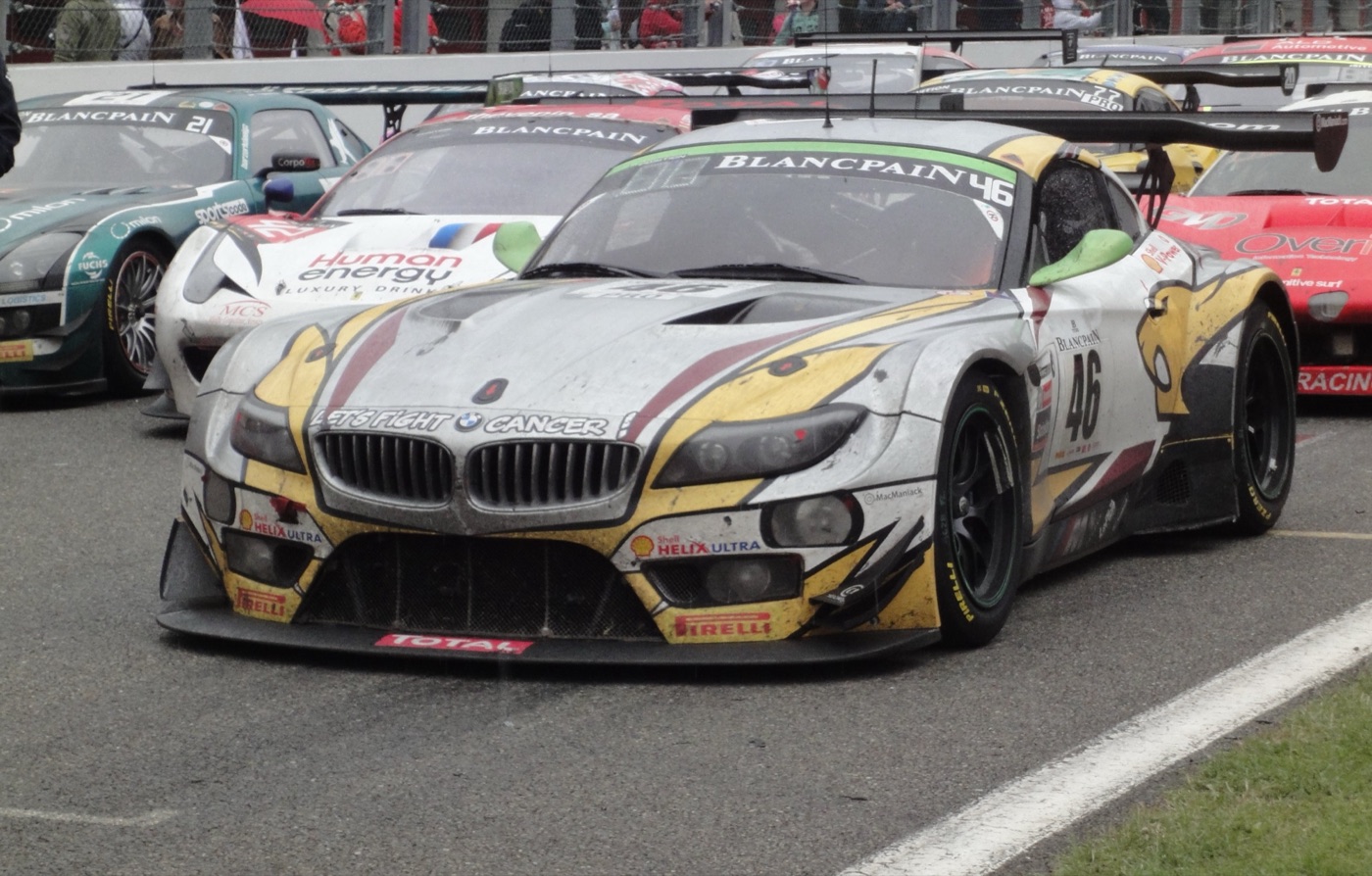 Silver, yellow and black BMW Z4 GT3 number 46, dirty from racing, parked on the grid