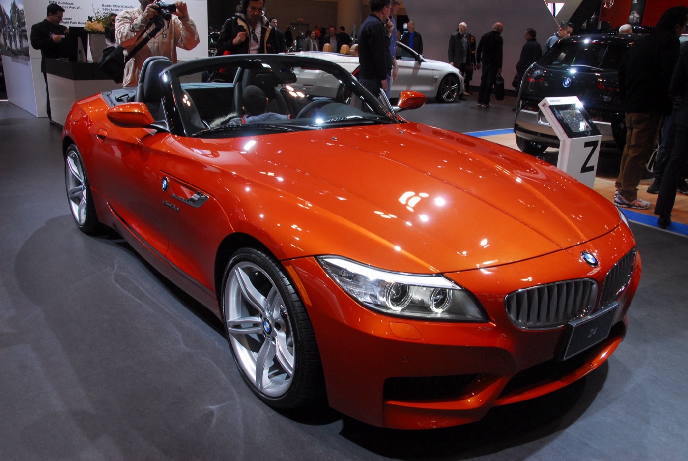 Facelifted BMW Z4 in Valencia Orange metallic with the roof folded, on a motor show stand