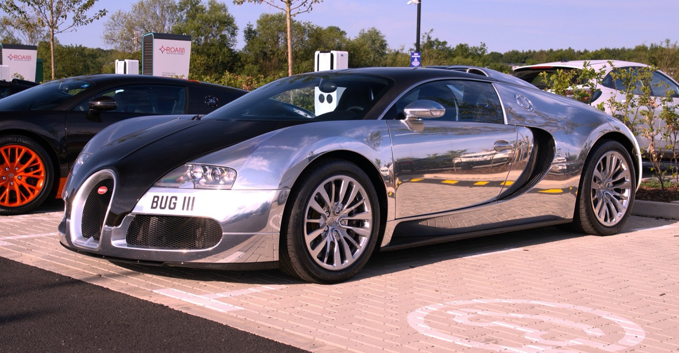 Bugatti Veyron Pur Sang with a polished bare aluminium body and black exposed carbon bonnet and roof, parked in a car park