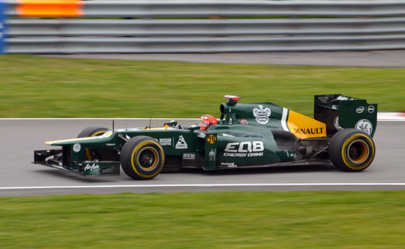 Dark green and yellow Caterham CT01 Formula One car with EQ8 and Renault logos on track, side view