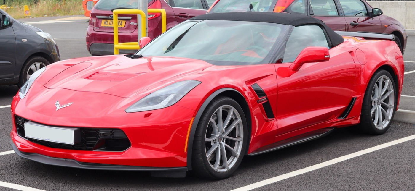 Red C7 Corvette Grand Sport convertible with the roof up and silver wheels, in a car park