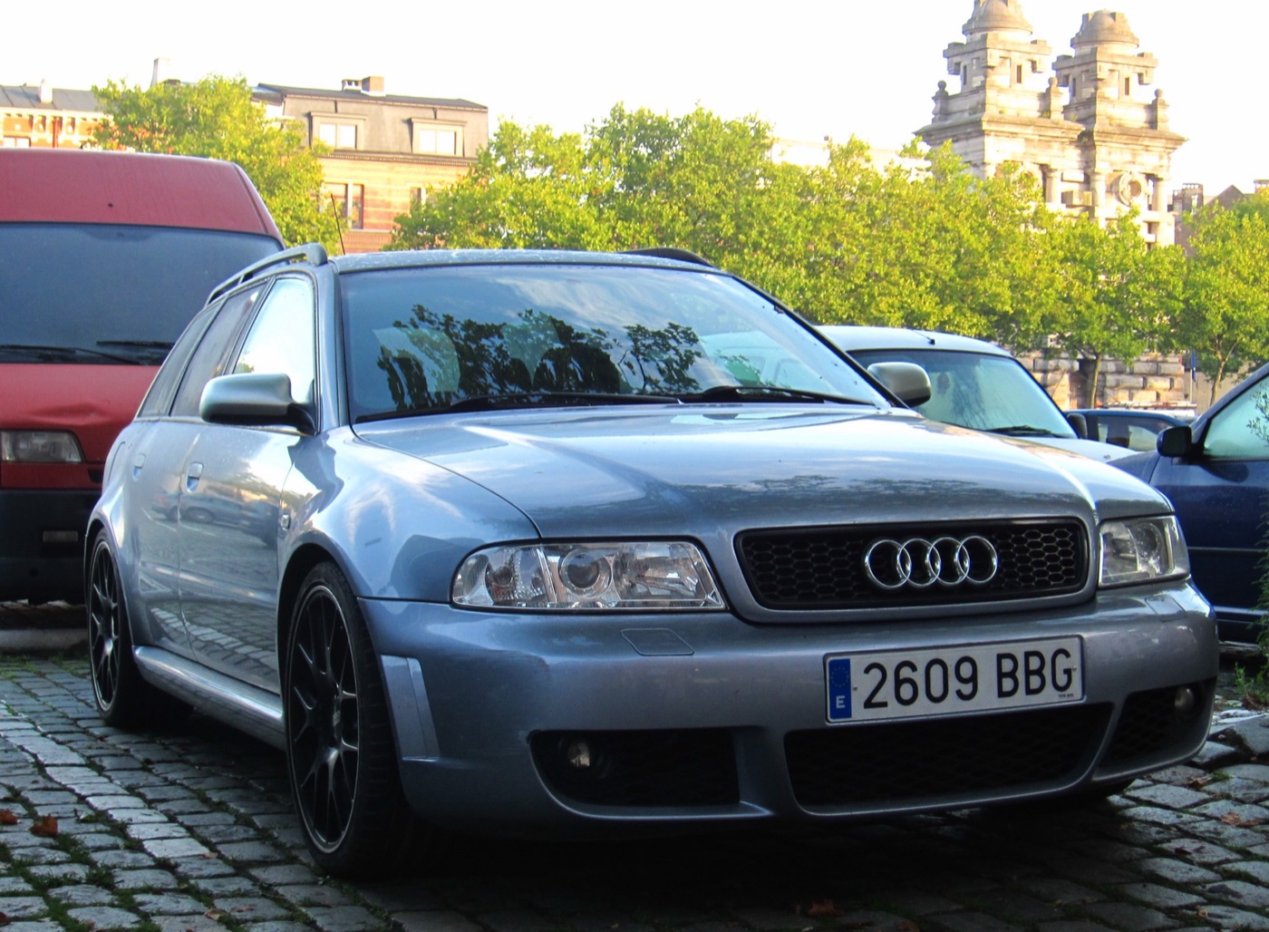 Silver-blue Audi RS4 B5 Avant estate with black alloy wheels and flared arches parked on cobbles