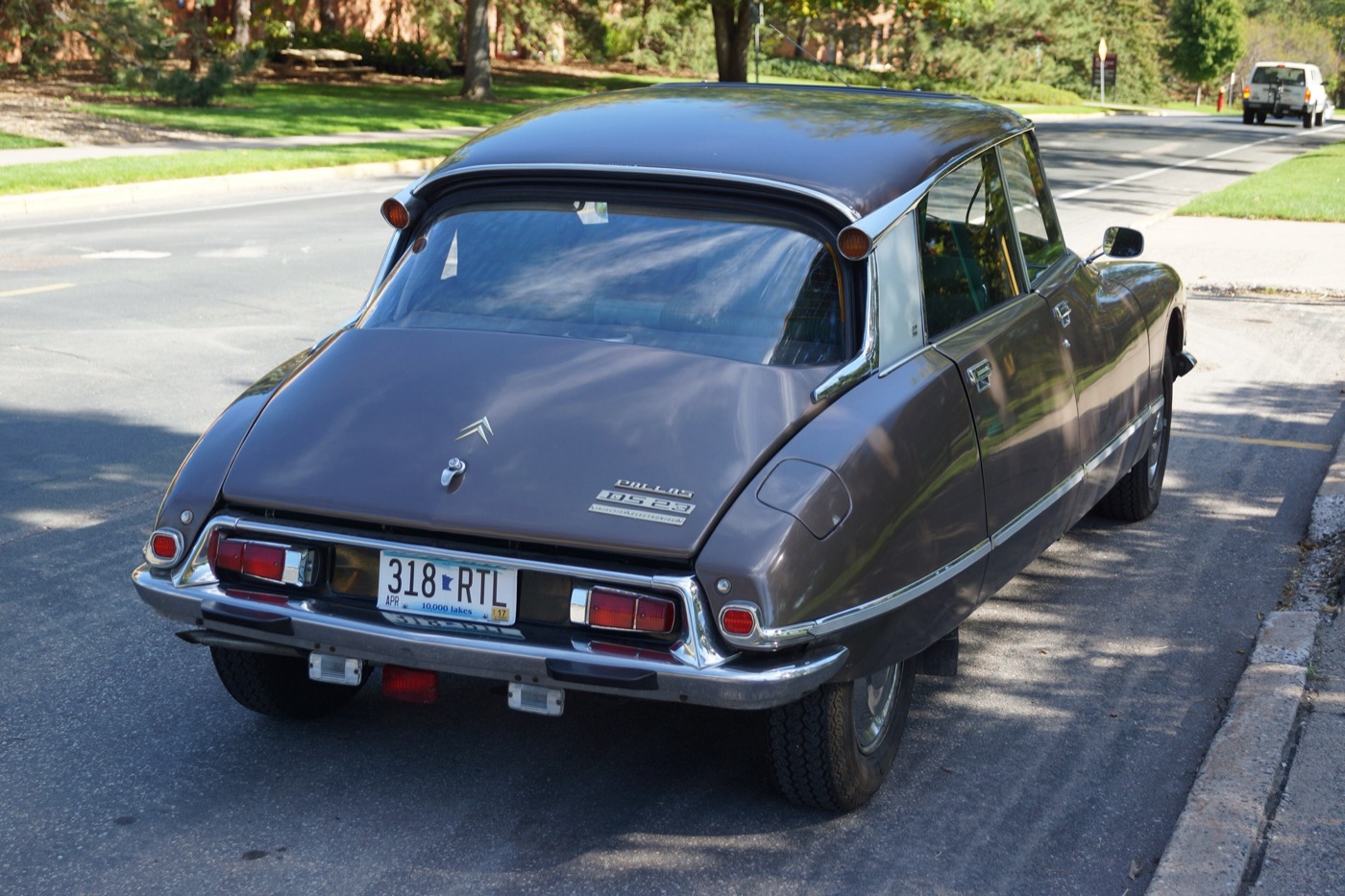 Brown 1973 Citroën DS 23 Pallas saloon from the rear quarter, with its Pallas and injection badges on the boot lid, parked on a street
