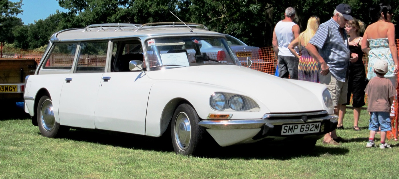 White right-hand-drive Citroën DS 23 Safari estate with roof rails, parked on grass at a show in England