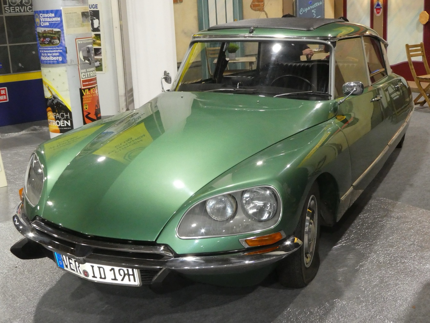 Metallic green Citroën ID19 of 1967 to 1969 with four faired-in headlamps, shown indoors at a classic car show