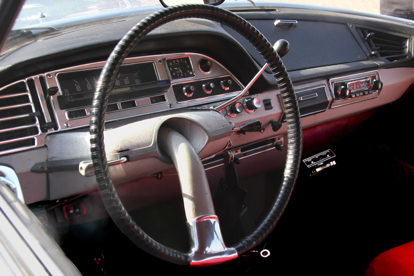 The single-spoke steering wheel and grey dashboard of a Citroën DS, with the hydraulic gear lever above the steering column