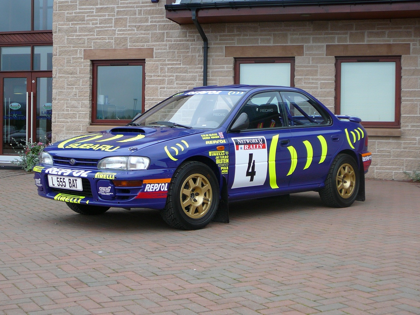 Colin McRae’s blue and yellow Subaru Impreza 555 rally car, number 4, with gold wheels, parked in Lanark