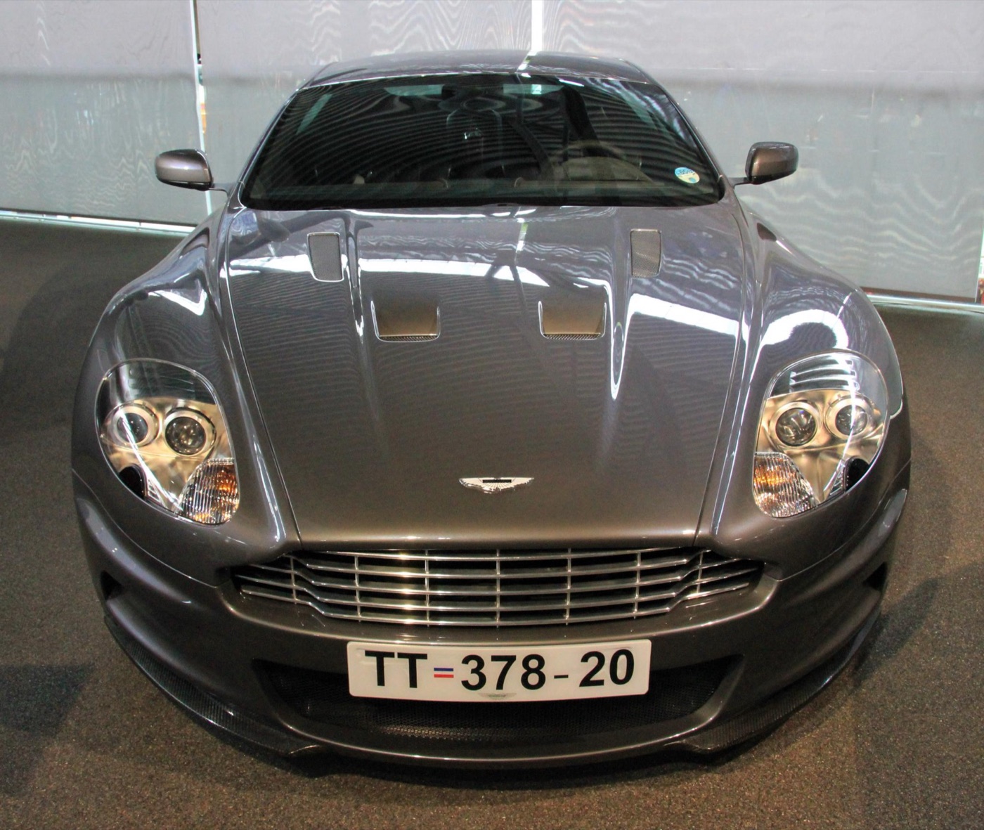 Front view of a grey Aston Martin DBS with twin bonnet vents and the number plate TT 378 20
