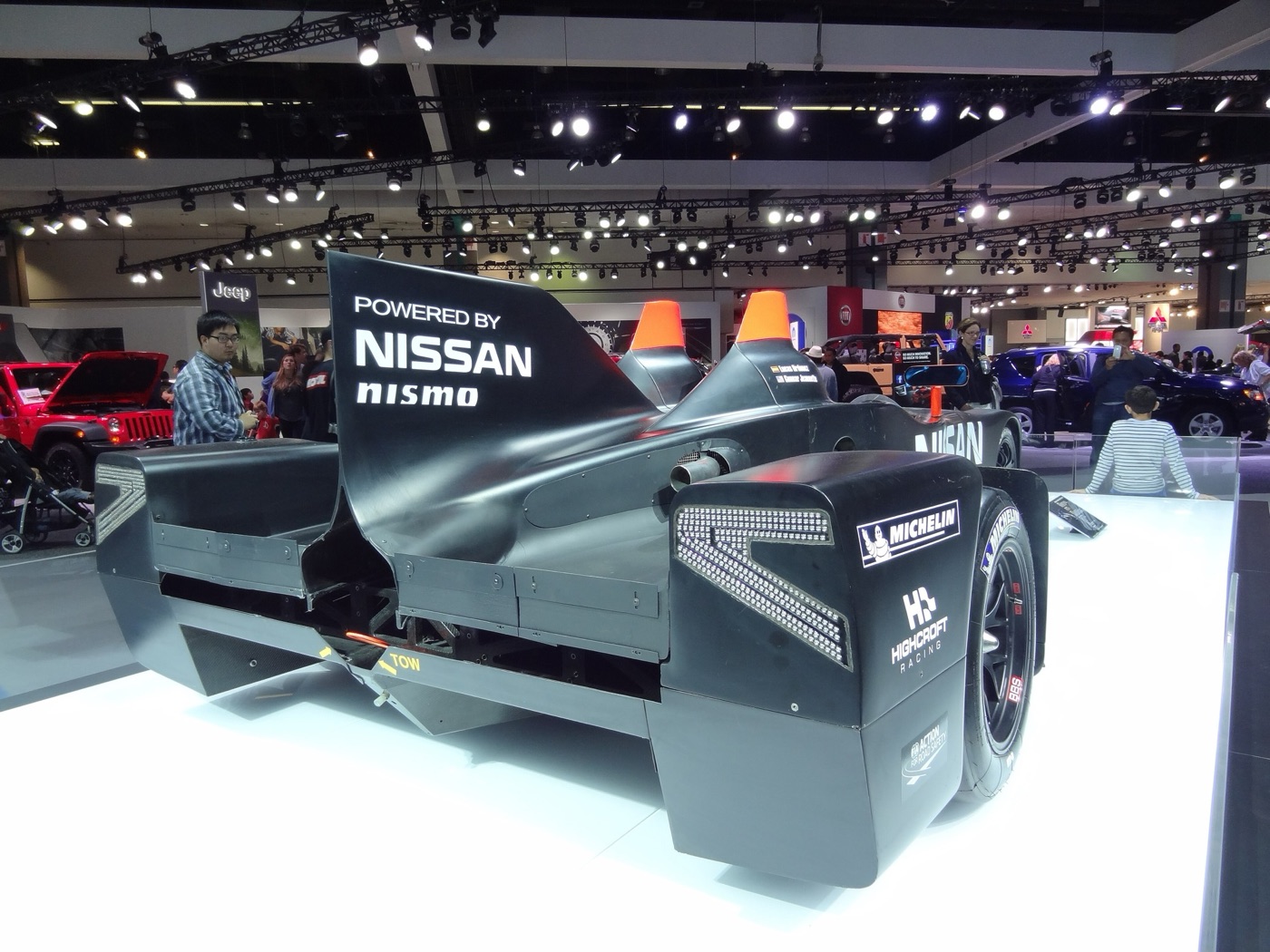 Rear view of the black DeltaWing on a show stand, with its tall fin, wide rear track and Highcroft Racing and Michelin logos