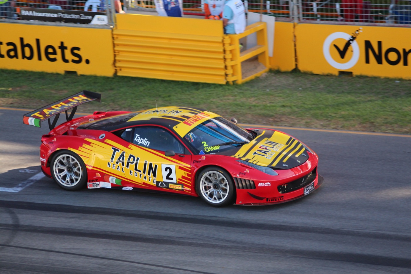 Red and yellow Ferrari 458 GT3 race car number 2 with a large rear wing on a street circuit