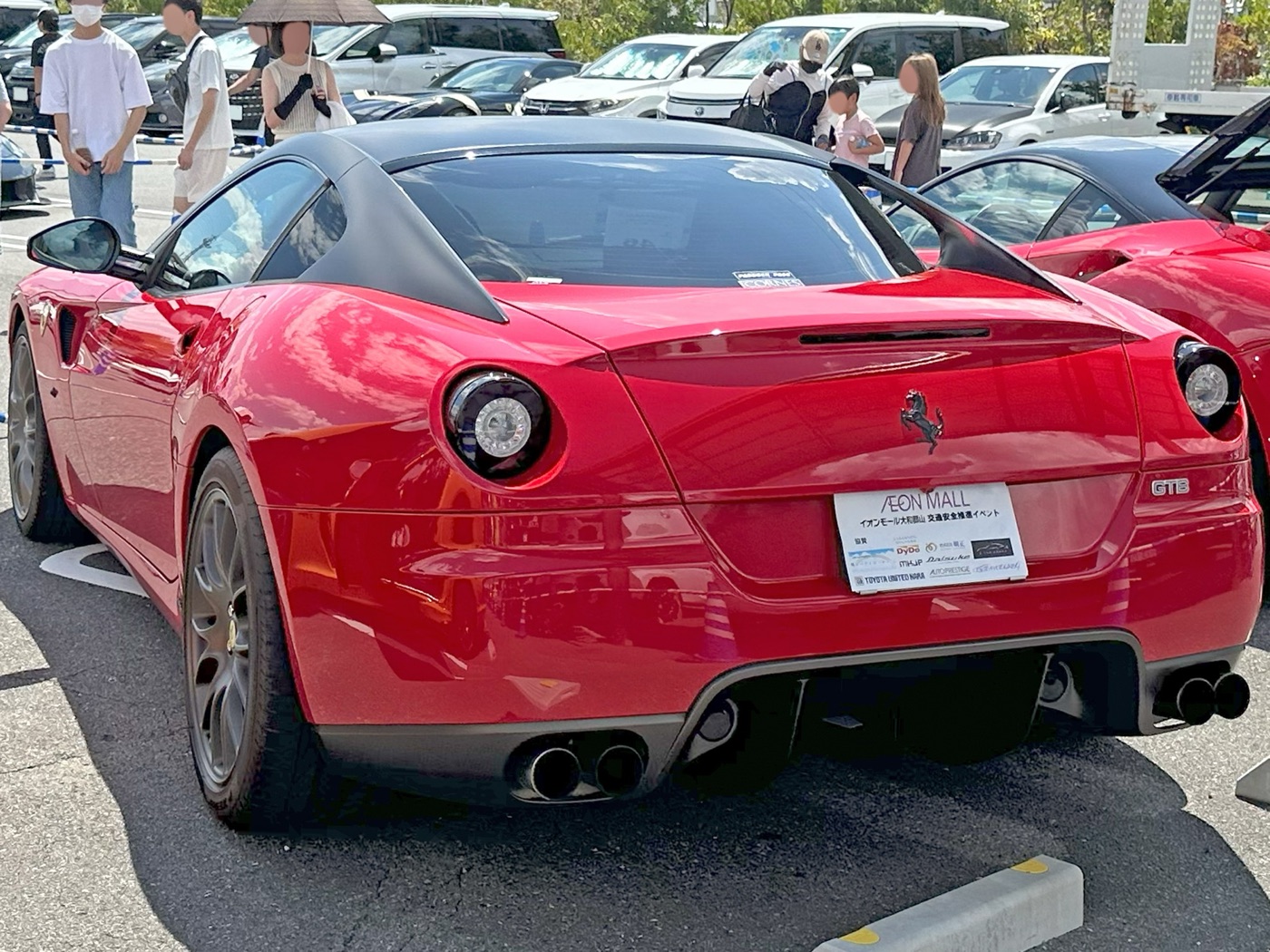Rear of a red Ferrari 599 GTB with black flying buttresses either side of the rear window and four exhaust pipes