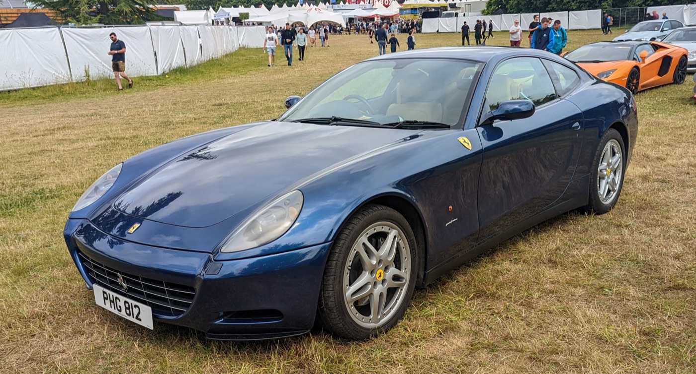 Dark blue Ferrari 612 Scaglietti coupé parked on grass at a car show