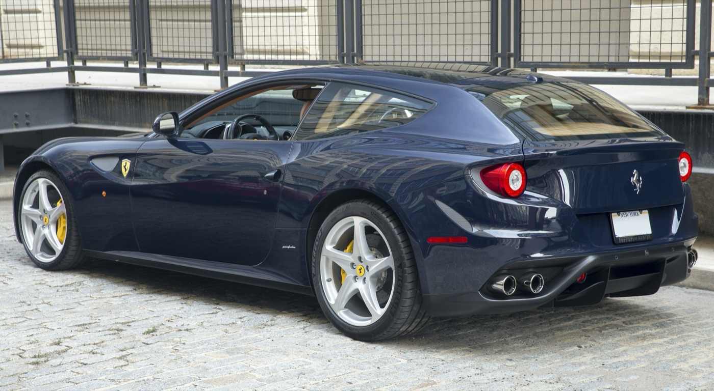 Dark blue Ferrari FF seen from the rear left, showing the tailgate, twin round tail lights and four exhaust pipes
