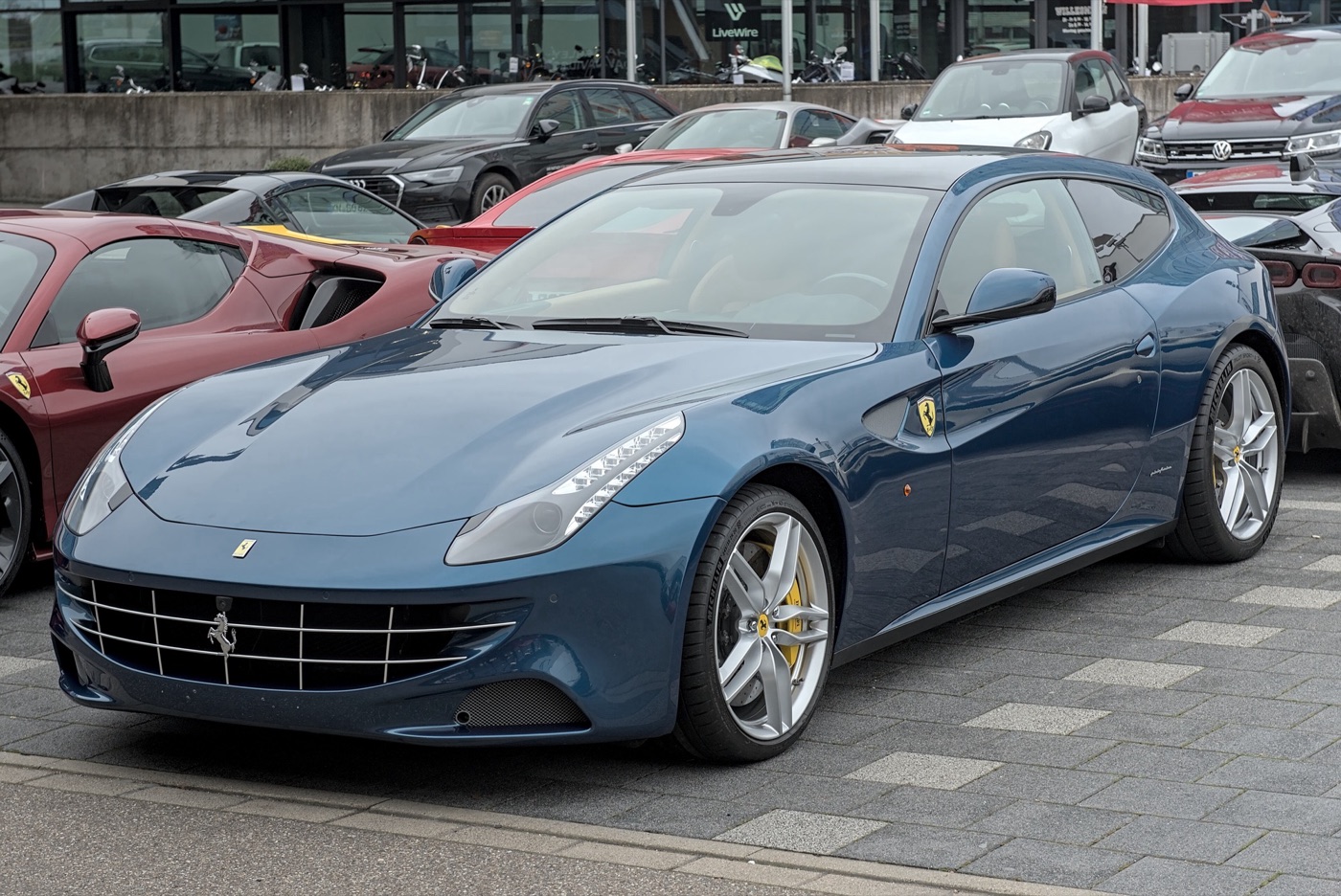 Dark blue Ferrari FF shooting brake seen from the front left, parked among other cars