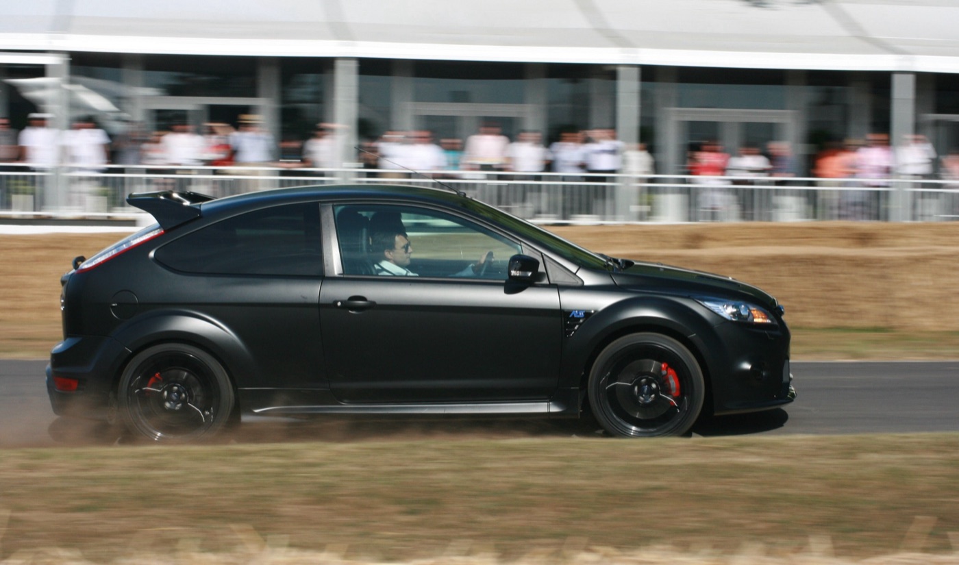 Matt black Focus RS500 accelerating up the hill past spectators at Goodwood